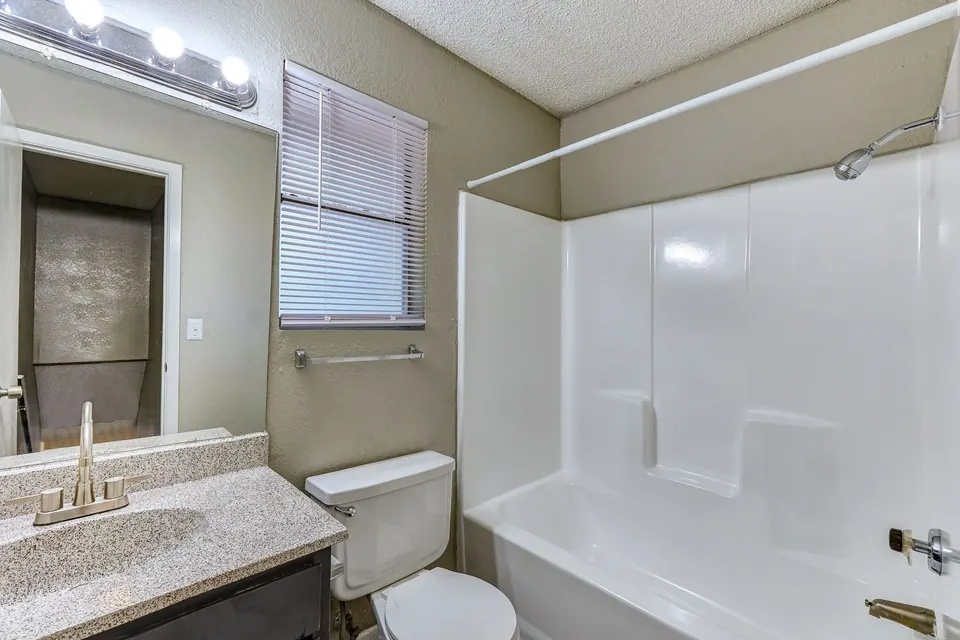 Bathroom with a tub-shower and a granite-look vanity