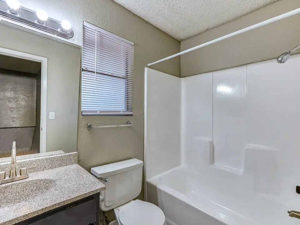Bathroom with a tub-shower and a granite-look vanity