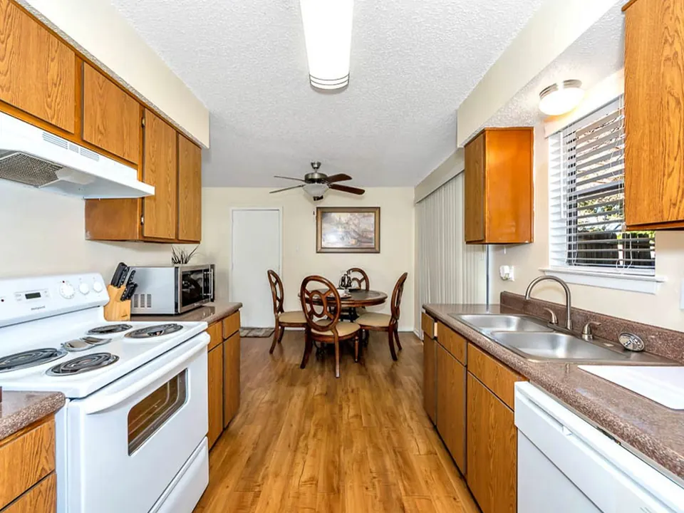 Kitchen with oak cabinets, white appliances and a dining nook in a White Oak townhome