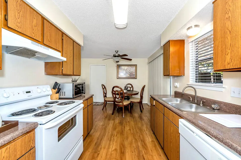 Kitchen with oak cabinets, white appliances and a dining nook in a White Oak townhome