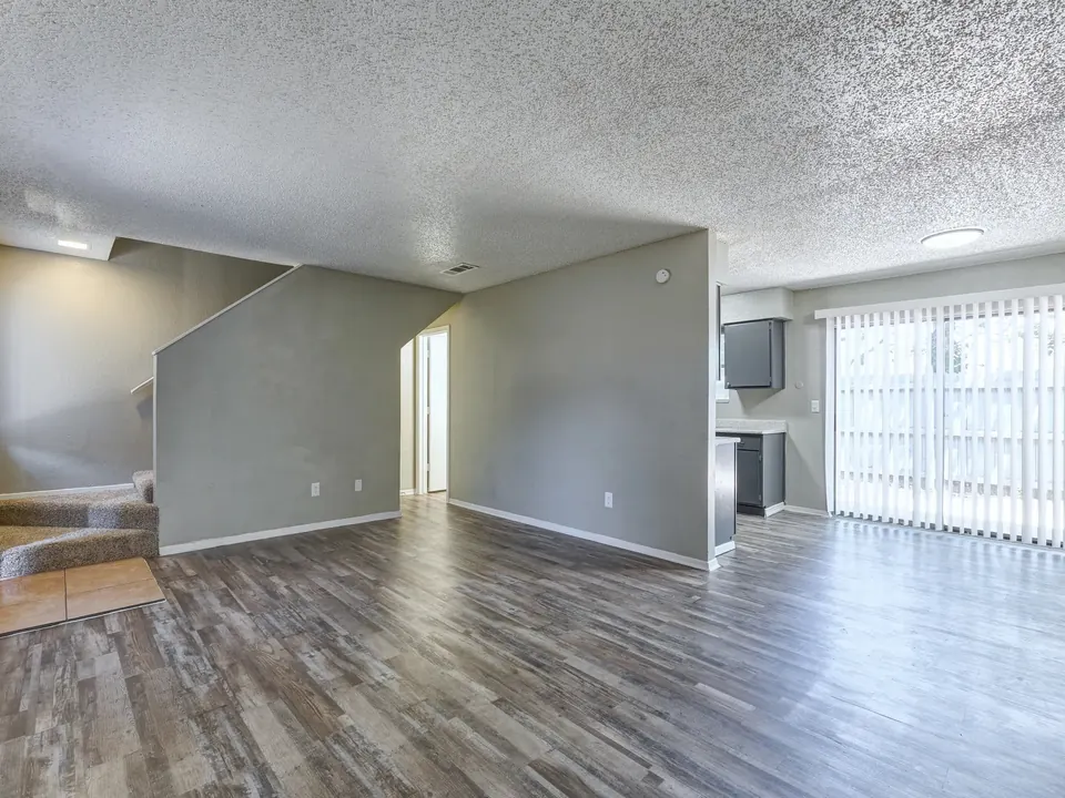 Renovated living room with a staircase and patio door in a Modern Grey townhome