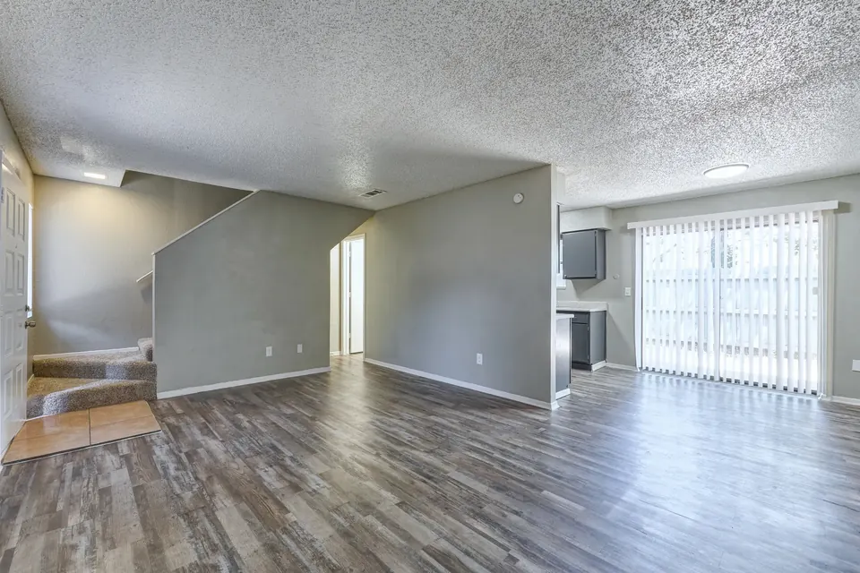Renovated living room with a staircase and patio door in a Modern Grey townhome