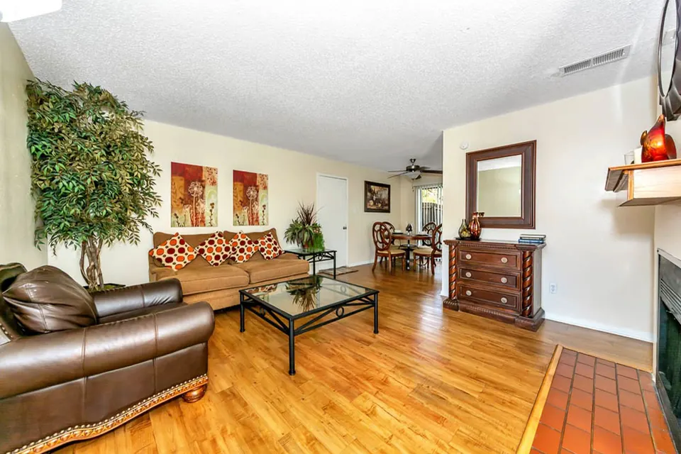 Living room with a fireplace and wood-look floors in a White Oak townhome