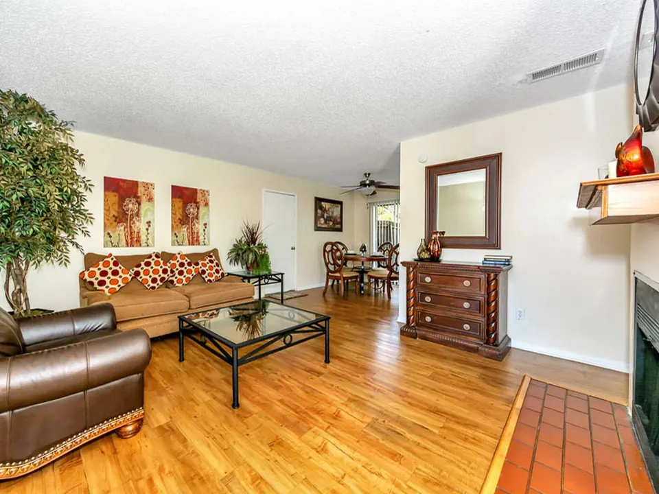 Living room with a fireplace and wood-look floors in a White Oak townhome