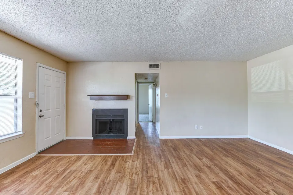 Living room with a fireplace and a front door to the street in a White Oak townhome