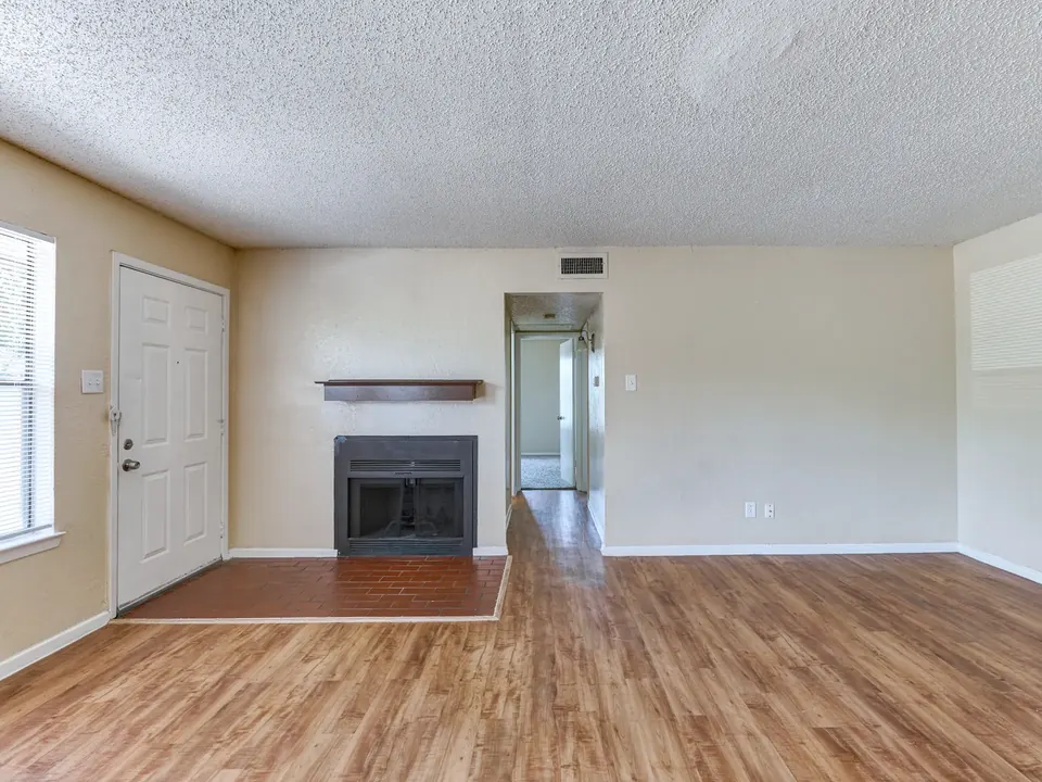 Living room with a fireplace and a front door to the street in a White Oak townhome
