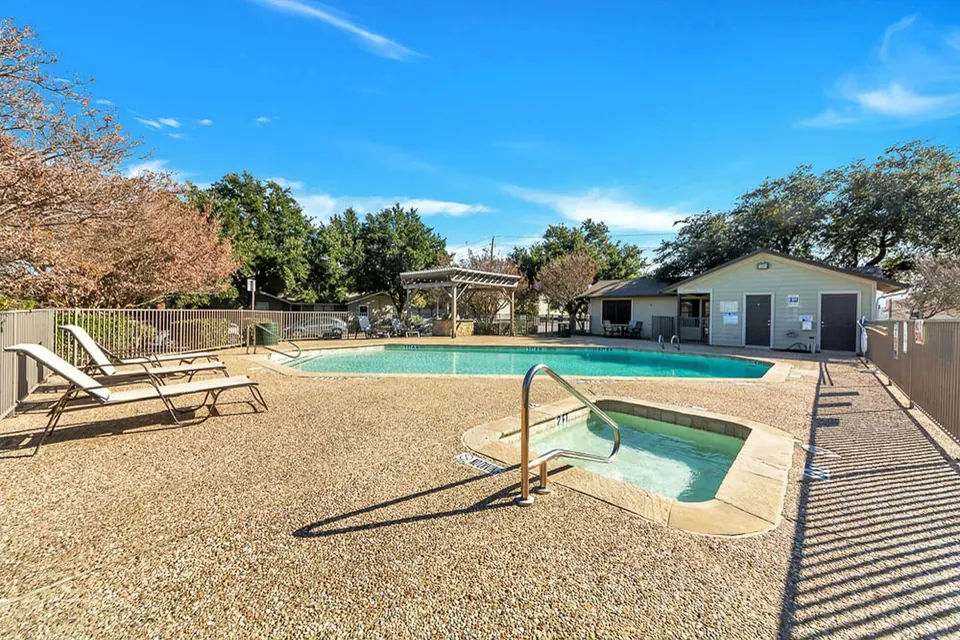 Outdoor pool and spa with lounge chairs at Cedar Ridge Townhomes in Arlington, TX