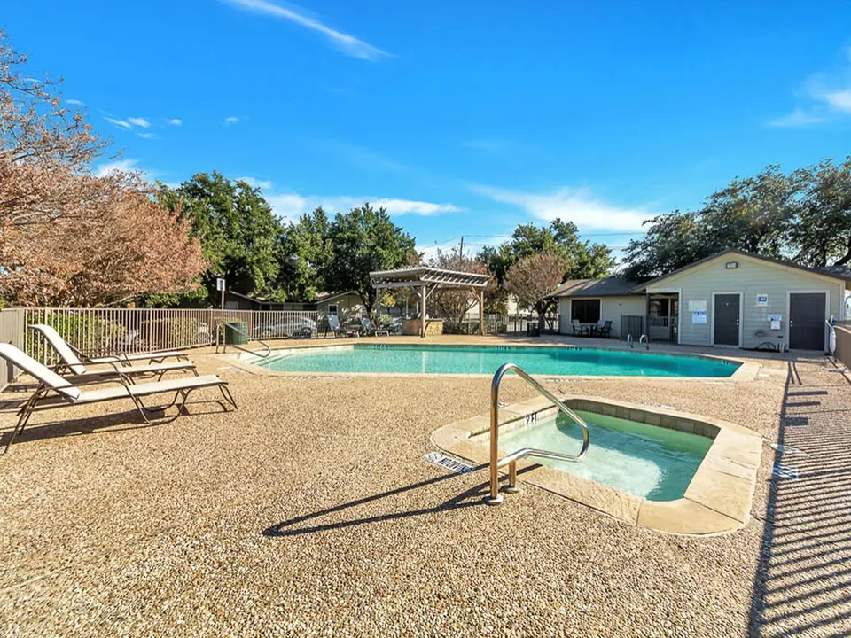 Outdoor pool and spa with lounge chairs at Cedar Ridge Townhomes in Arlington, TX