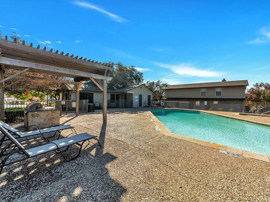 Pool deck with a pergola and grill at Cedar Ridge Townhomes