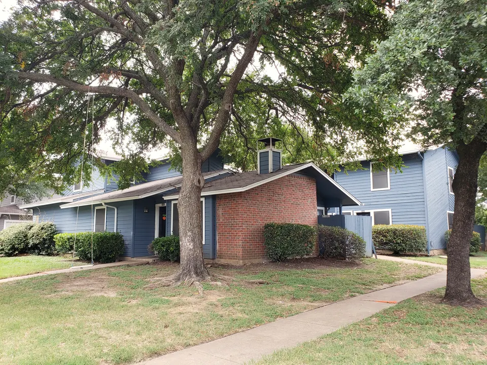 Townhome with a shaded yard under mature oak trees